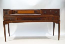 An Edwardian mahogany square piano converted to a desk with central curved drawer and four further