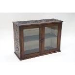 A Victorian oak glazed hanging cabinet, constructed from old timbers, bearing carved decoration, 51.