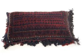 A Middle Eastern tasslled carpet cushion,