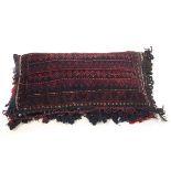 A Middle Eastern tasslled carpet cushion,