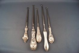 Five silver handled button hooks, comprising; a plain example with shaped handle,
