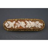 A gilt-metal and shell cameo oblong brooch depicting trailing flowers in Victorian style within a