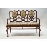 A pair of modern hardwood triple back settees with scrolling floral upholstery,