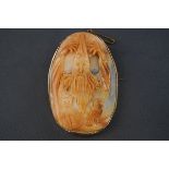 A cameo brooch depicting a wizard, a cat and an owl,