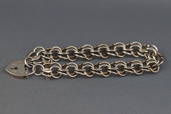 A silver three row curb bracelet on a padlock clasp, London 1978, 19.