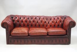 A red leather three seater Chesterfield sofa,
