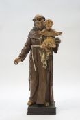 A Czech carved and painted figure of St Anthony holding the infant Jesus,