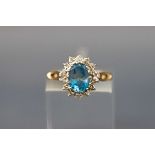 A 9ct gold, blue topaz and diamond oval cluster ring, London 1988, size K, 2.