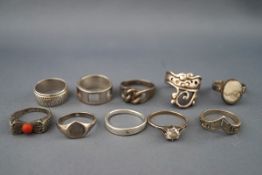 A collection of ten silver and white metal rings in various designs including an example set with