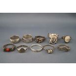 A collection of ten silver and white metal rings in various designs including an example set with