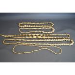 Three Chinese carved bone bead necklaces; an early 20th century ivory graduated oval bead necklace;