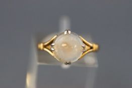 A 9 carat gold ring claw set with a circular cabochon moonstone. Stamped 9ct. Size: M 2.