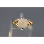 A 9 carat gold ring claw set with a circular cabochon moonstone. Stamped 9ct. Size: M 2.