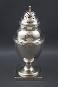 A George III silver vase shaped sugar caster on a square base with reeded borders and domed cover