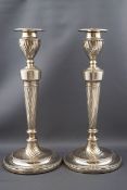 A pair of late Victorian silver round candlesticks, each with a spiral fluted capital,