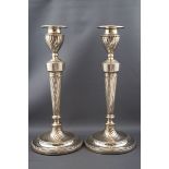 A pair of late Victorian silver round candlesticks, each with a spiral fluted capital,