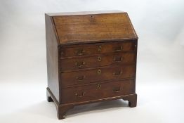 A George III oak bureau with pigeon hole and drawer interior,