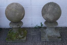 A pair of garden reconstituted stone ball and pedestal ornaments,