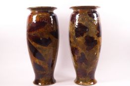 A pair of Royal Doulton earthenware vases with Autumnal decoration of leaves on an ochre ground,