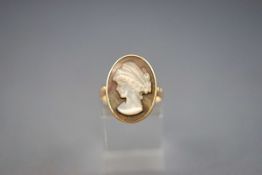 A yellow gold ring set with a carved mother of pearl cameo. Stamped K14 for 14ct gold. Size: P 3.