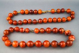 Two necklaces, comprising; a banded carnelian single row necklace, the beads graduated approx. 15.