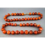 Two necklaces, comprising; a banded carnelian single row necklace, the beads graduated approx. 15.