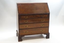 A George III mahogany bureau, the fall front enclosing a pigeon hole and drawer interior,