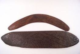 A carved Aboriginal boomerang and a similar flat wood carving,