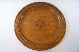 A large circular oak platter with carved script 'The Edinburgh Academy',