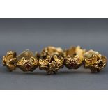 A Victorian silver gilt bracelet having hinged links with engraved floral design and set with red