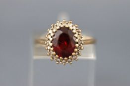 A 9ct gold, garnet and diamond oval cluster ring, Birmingham 1994, size L, 3.