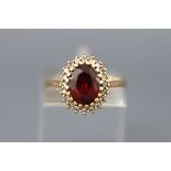 A 9ct gold, garnet and diamond oval cluster ring, Birmingham 1994, size L, 3.