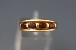 A modern 9ct gold and oval burnt-orange citrine four stone ring,
