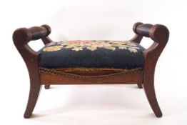 A 19th century mahogany footstool with turned handles, reeded legs and tapestry upholstery,