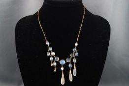 A yellow gold centrepiece fringe necklace set with graduating moonstone cabochon and suspended from