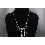 A yellow gold centrepiece fringe necklace set with graduating moonstone cabochon and suspended from