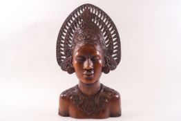 A carved hardwood bust of a Balinese lady weaaring an elaborate headdress,