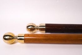 A near pair of carved walking sticks,