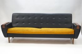 A 1970's button back black leatherette and fabric sofa, 74cm high x 208cm wide x 86cm deep,