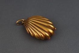 A yellow gold locket stylized as a shell with hinged fitting and centre glass. Oval bail.