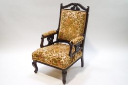 A Victorian mahogany armchair with floral upholstery in relief
