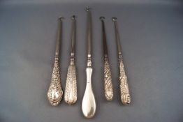 Five silver handled button hooks,
