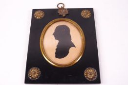 A 19th century silhouette of a Gentleman mounted in an ebonised frame with brass corner roundels
