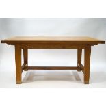 An oak extending refectory table with two loose leaves, square legs linked by 'H' stretchers,