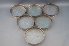 A set of six Sterling and glass bottomed small coasters,