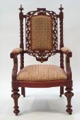A Victorian painted armchair with carved and pierced back and barley twist supports,