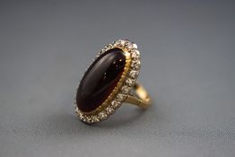 A yellow and white metal cabochon almandine garnet and diamond cluster ring.