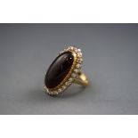 A yellow and white metal cabochon almandine garnet and diamond cluster ring.