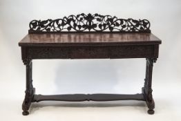 An Indian carved hardwood sideboard with ornately carved crest rail and ends, joined by a stretcher,