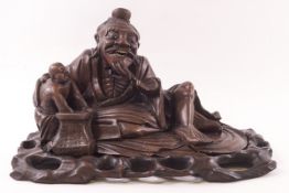 A Chinese root carving of a seated wiseman and small figure, 17cm high x 26cm wide,